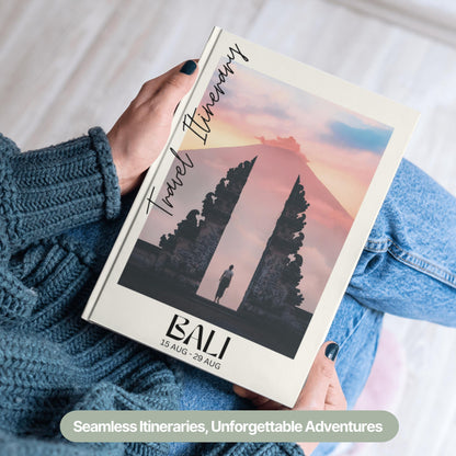 A person wearing a cozy blue sweater and jeans is holding a hardcover travel itinerary book.