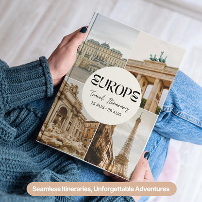 A person wearing a cozy blue sweater and jeans is holding a hardcover travel itinerary book.
