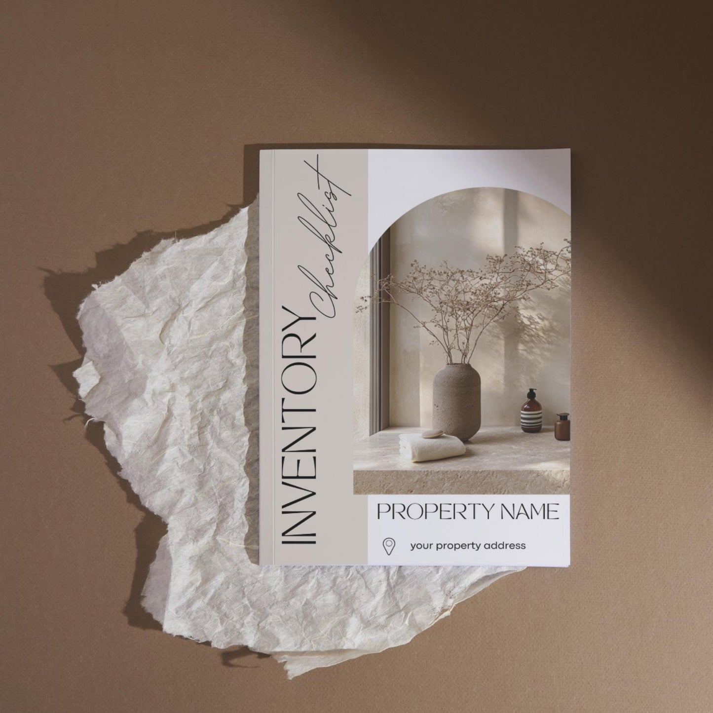 A stylish “Inventory Checklist” booklet is placed on a piece of crumpled white parchment against a warm brown background. The cover features minimalist design elements with soft beige tones and elegant fonts.