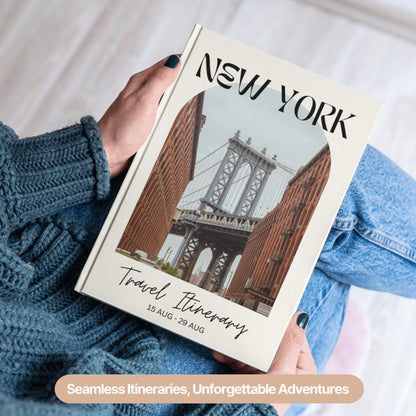 A person wearing a cozy blue sweater and jeans is holding a hardcover travel itinerary book.