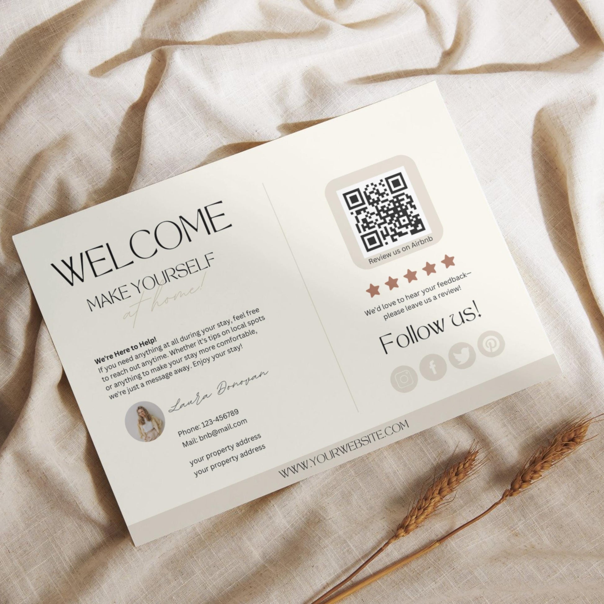 Flat lay of a modern Airbnb welcome card featuring guest information, a QR code for reviews, and social media icons, placed on a light linen fabric with dried wheat stalks.